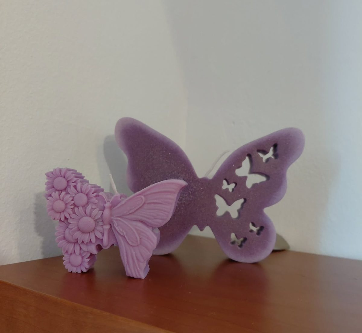 Vela de cera en forma de mariposa lila con florecitas